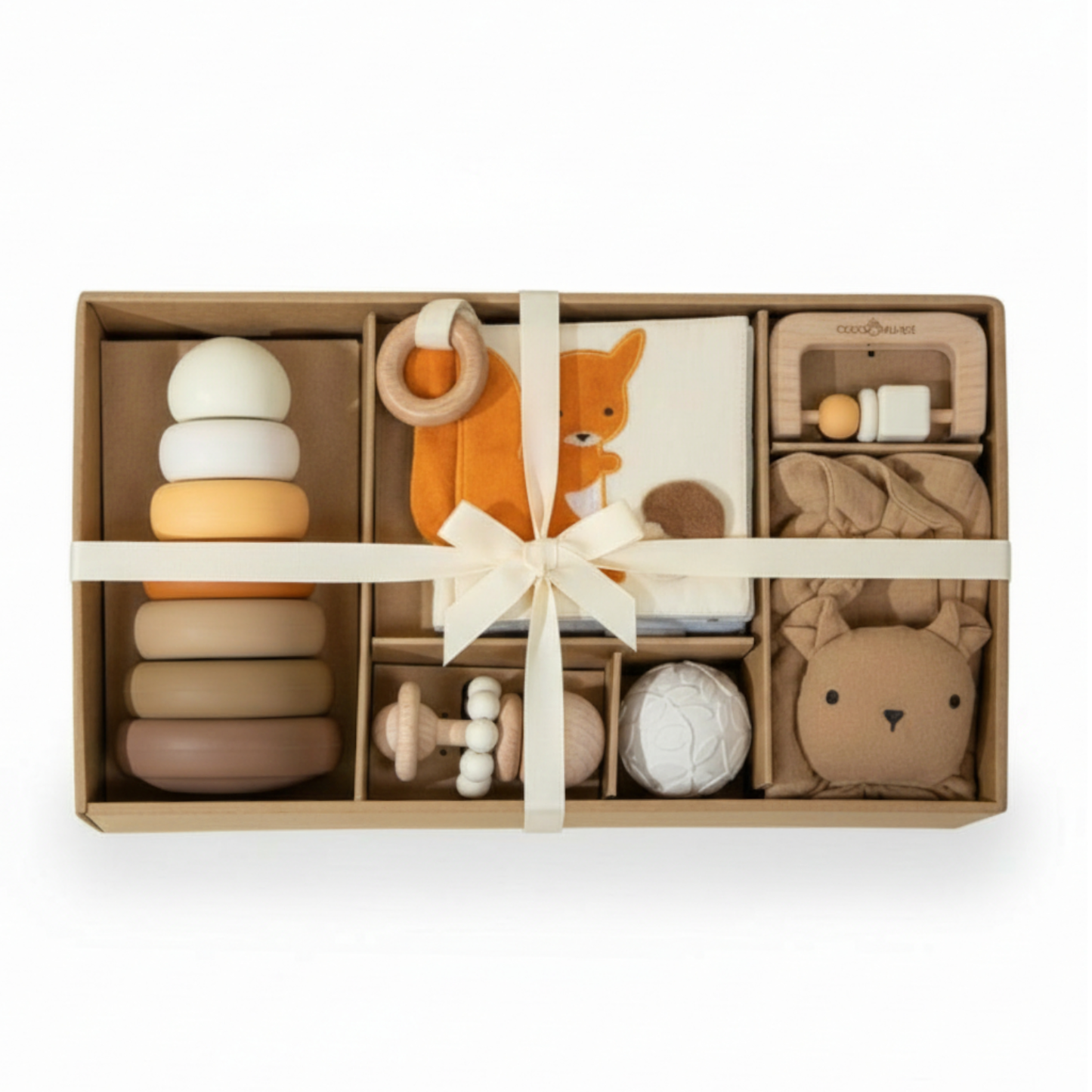 Modern newborn toy gift set with wooden rattle, silicone toys, lovey, and woodland-themed sensory book arranged in a kraft gift box.