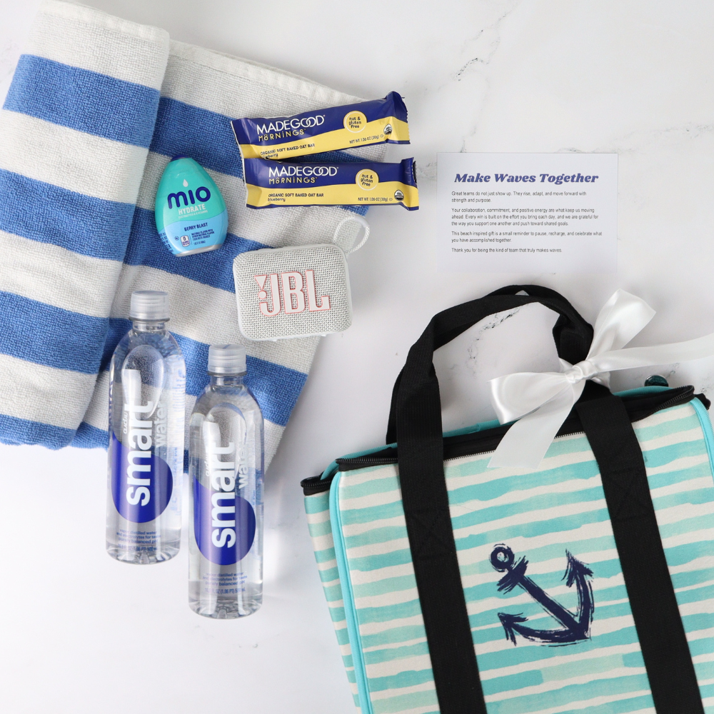 Collection of beach items including a striped towel, water bottles, a bag with an anchor design, and a JBL speaker on a white background.