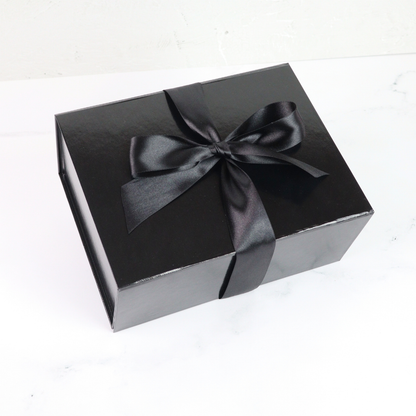 Black gift box with a black ribbon on a white background