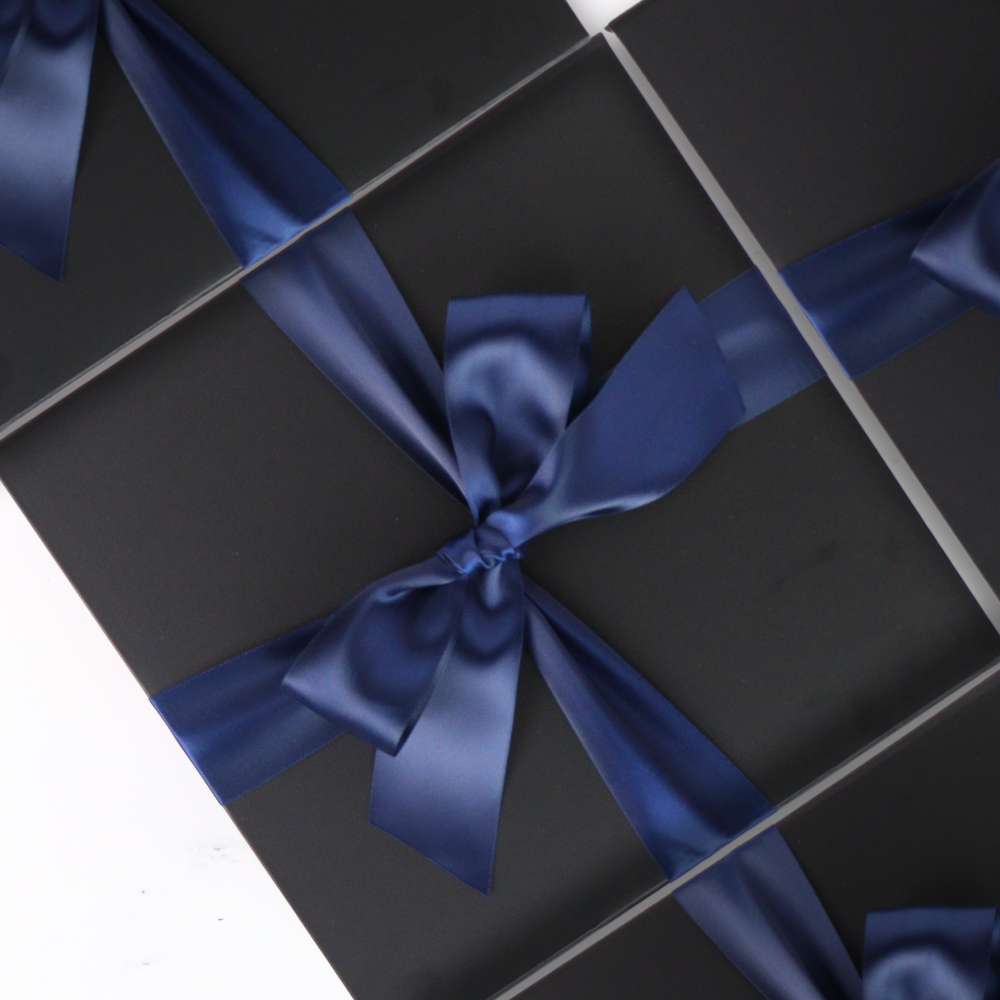 Black gift box with a blue ribbon on a white background