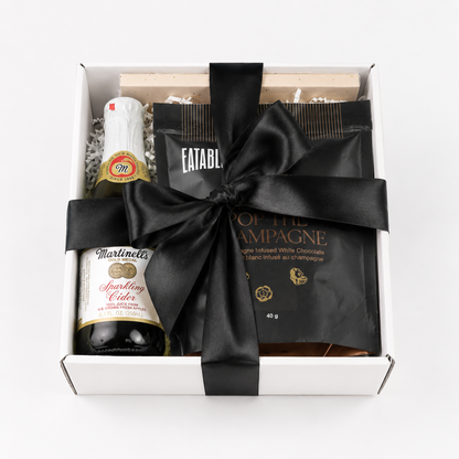 celebration gift box with black bow and popcorn, chocolate and sparkling cider