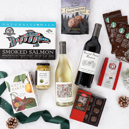 flat lay of gift basket contents including two bottles of wine, smoked salmon, chocolates and cookies
