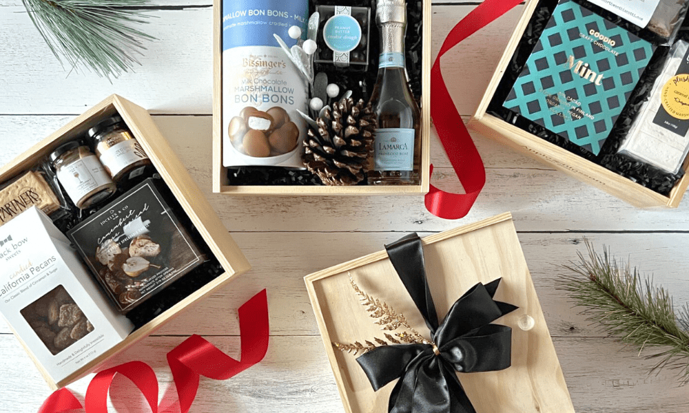 Collection of gift boxes with various items on a wooden surface.