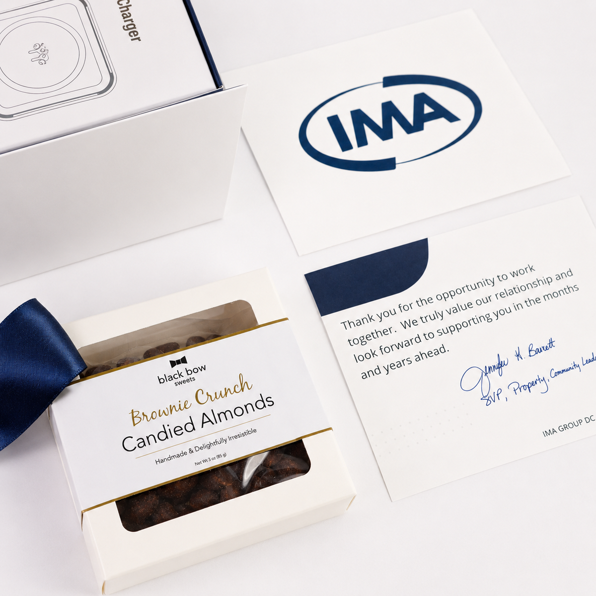 Box of 'Black Bow' brownie crunch candied almonds with a letter and IMA logo on a white background