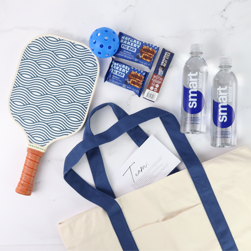 Pickleball paddle, sports bag, water bottles, and snacks on a white surface