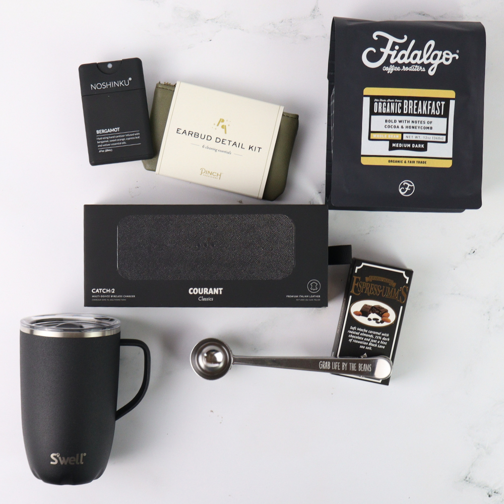 Collection of coffee-related items including a mug, coffee beans, and packaging on a white surface.