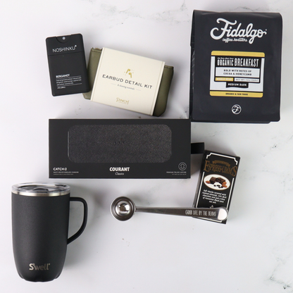 Collection of coffee-related items including a mug, coffee beans, and packaging on a white surface.