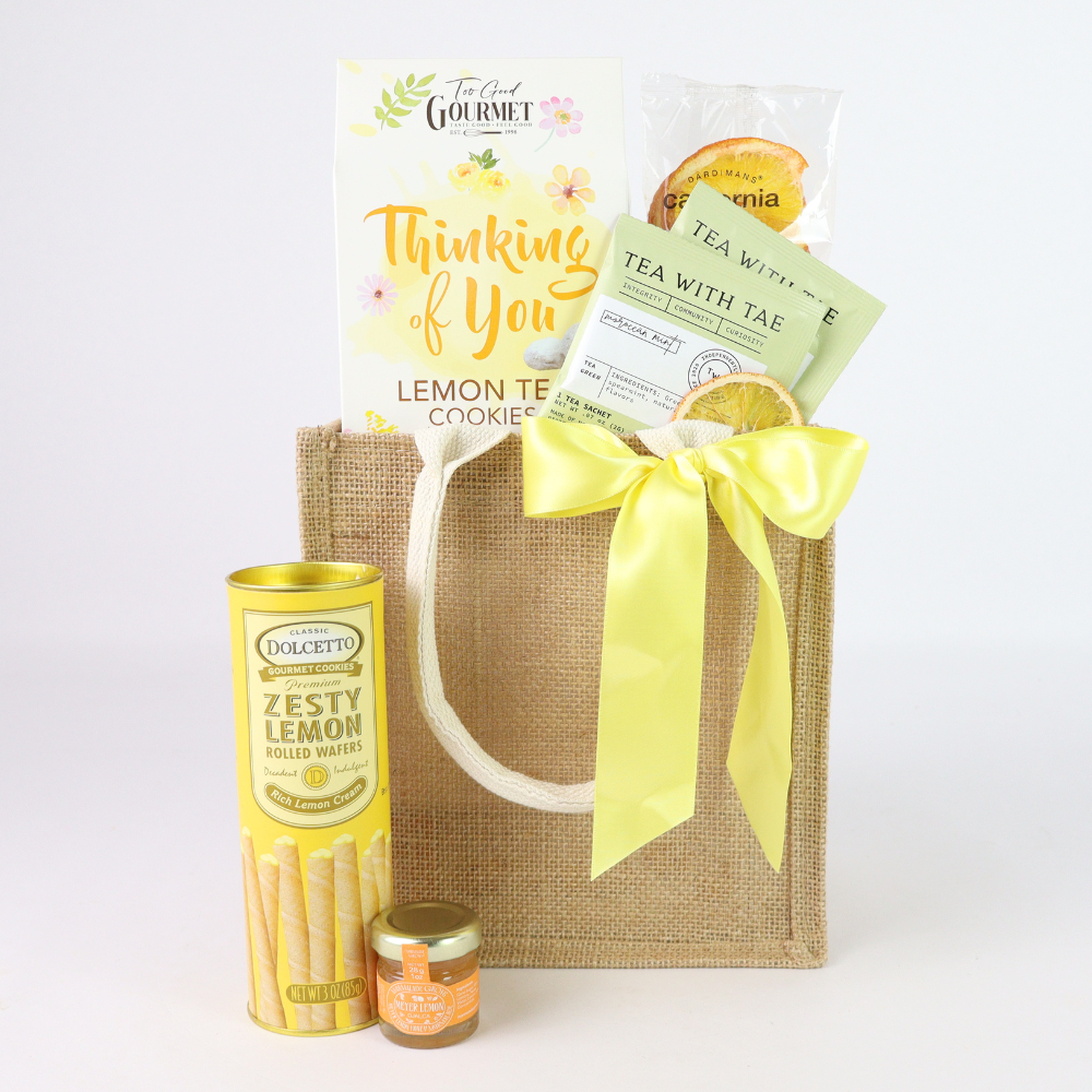 Gift basket with lemon-themed products including cookies, tea, and candies on a white background.
