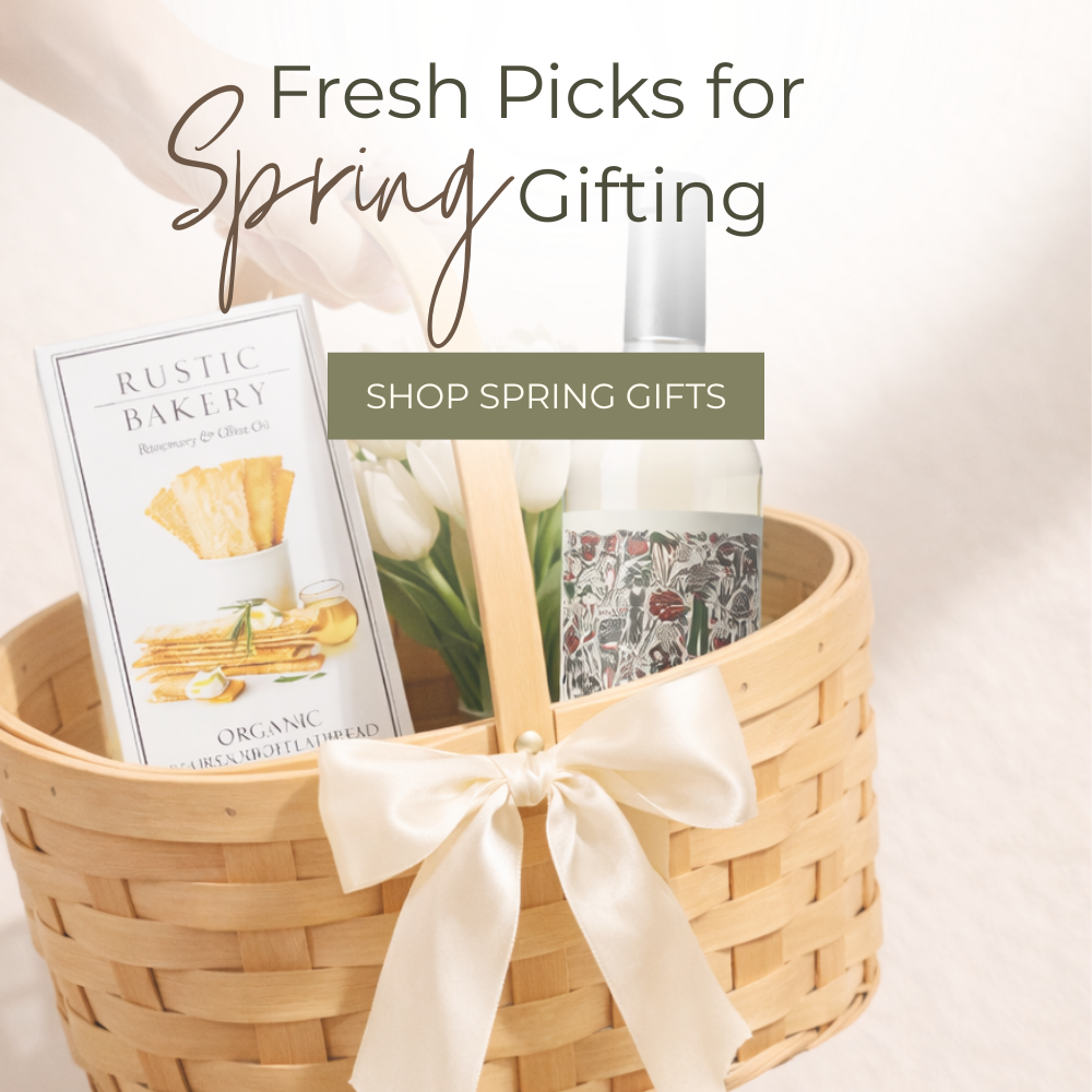Gift basket with a bottle, card, and flowers on a light background with text 'Fresh Picks for Spring Gifting'.
