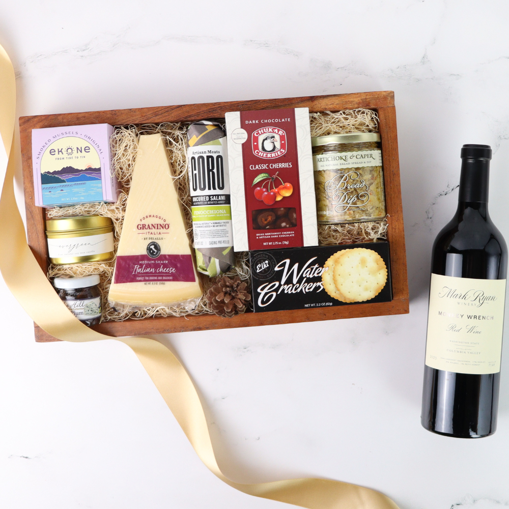 Gift basket with assorted foods and a bottle of wine on a white background