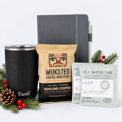 Workday Essentials coffee gift set with S'well tumbler, Mukilteo Coffee Roasters coffee, herbal tea and notebook, accented with festive greenery and berries.